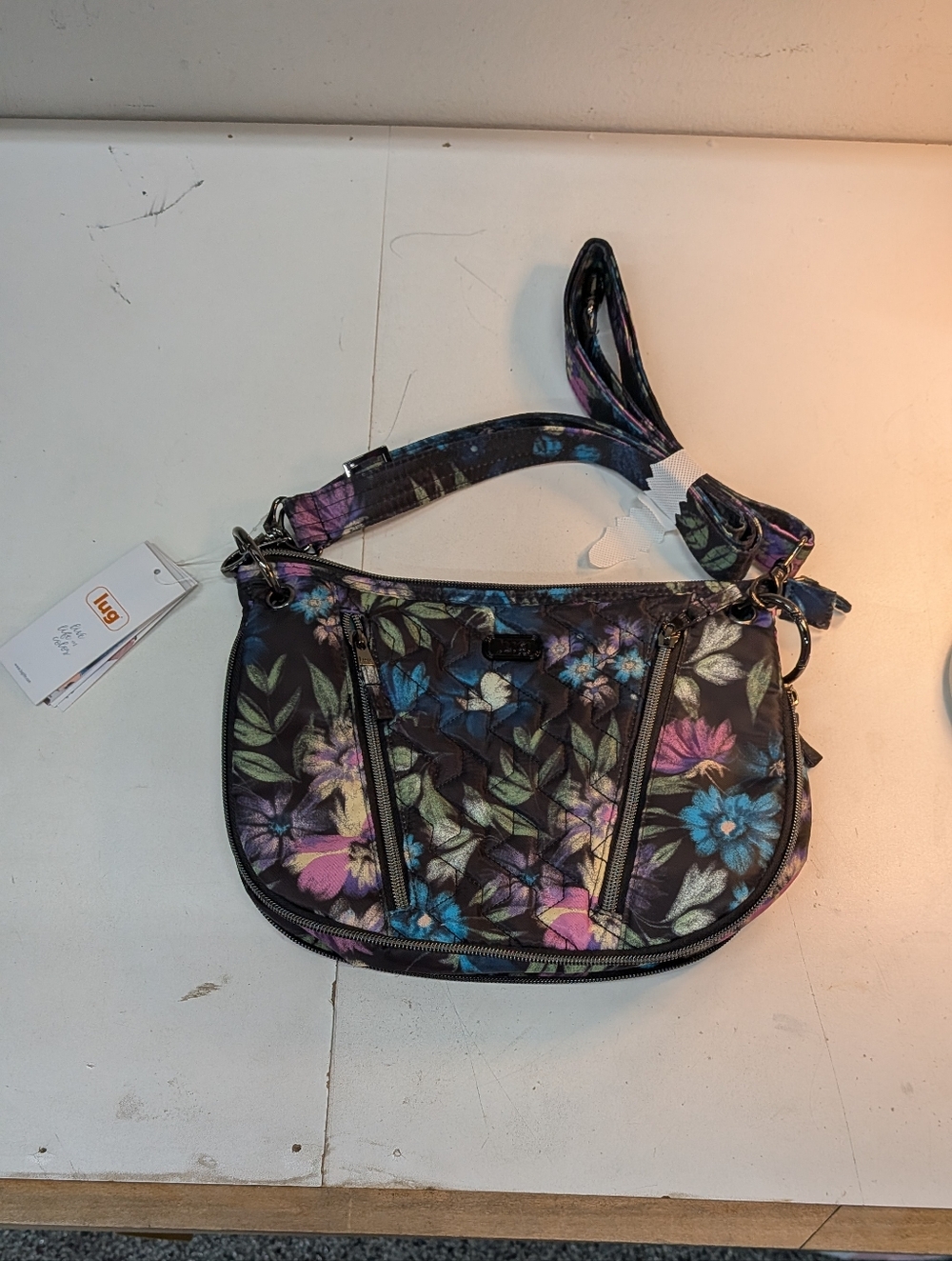 Lug Swivel  Floral Quilted Crossbody Bag in Black with Purple & Blue Accents.